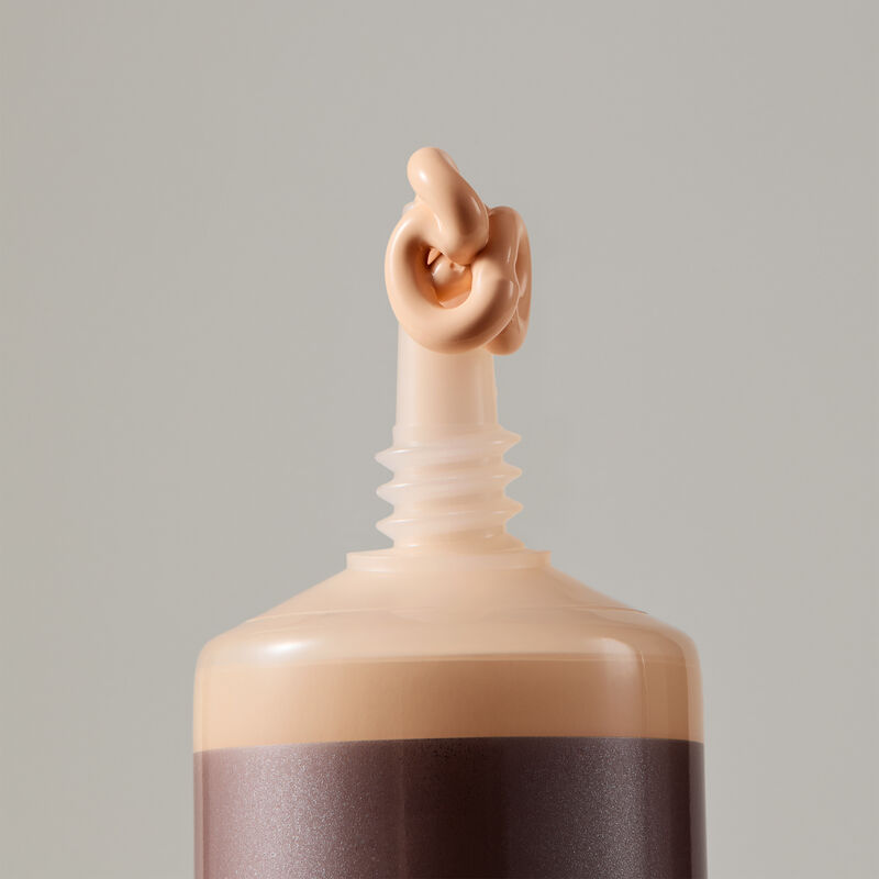 Macro view of TimeWise Matte 3D Foundation needle-nose applicator dispensing Light 1 shade