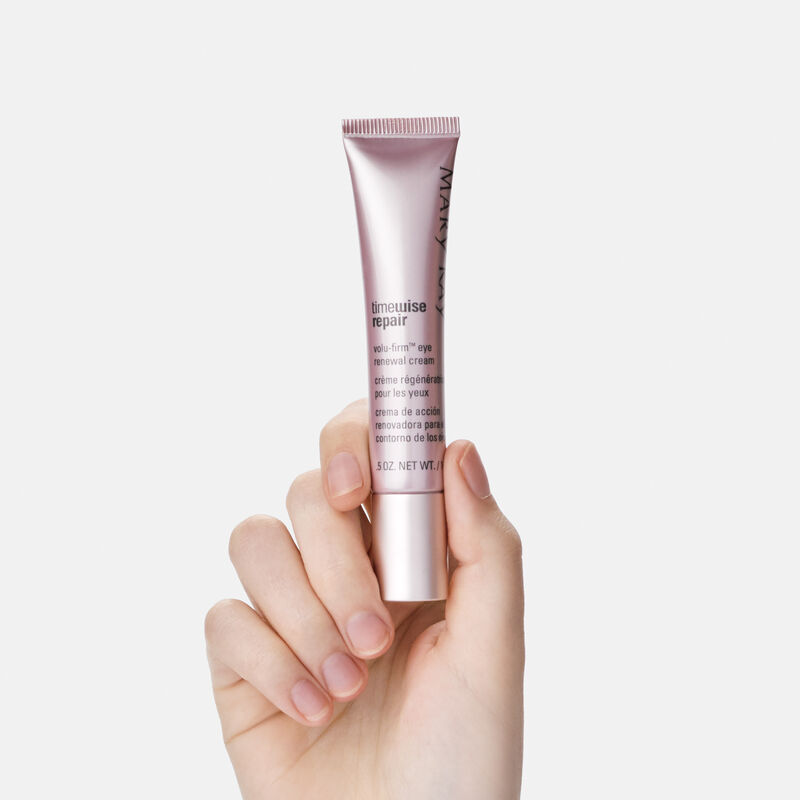 Une main tenant un tube de la Cr&egrave;me r&eacute;g&eacute;n&eacute;ratrice pour les yeux Volu-Firm TimeWise Repair de Mary Kay.