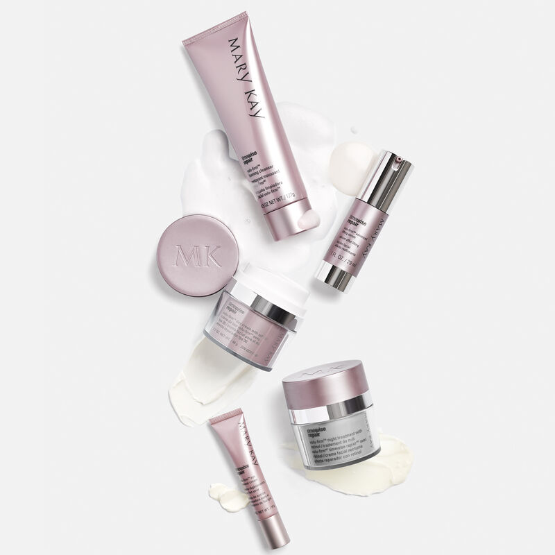 L&rsquo;Ensemble Volu-Firm TimeWise Repair Mary Kay sur un fond gris avec un frottis du produit derri&egrave;re chaque produit.