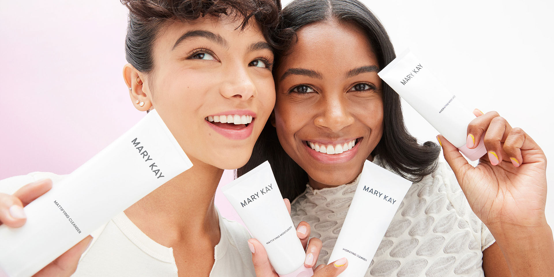 Two brunette models holding products of the Mary Kay Skin Care regimen and smiling