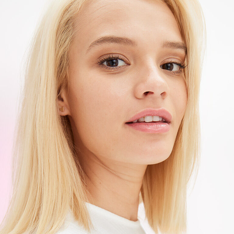 Un mannequin au maquillage naturel regarde la cam&eacute;ra.