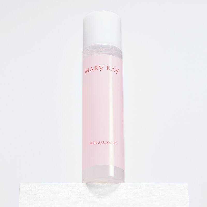 Bottle of Mary Kay Micellar Water standing on white platform against plain background