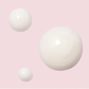 Gouttelettes du S&eacute;rum r&eacute;g&eacute;n&eacute;rateur C+E TimeWise Mary Kay sur un fond rose